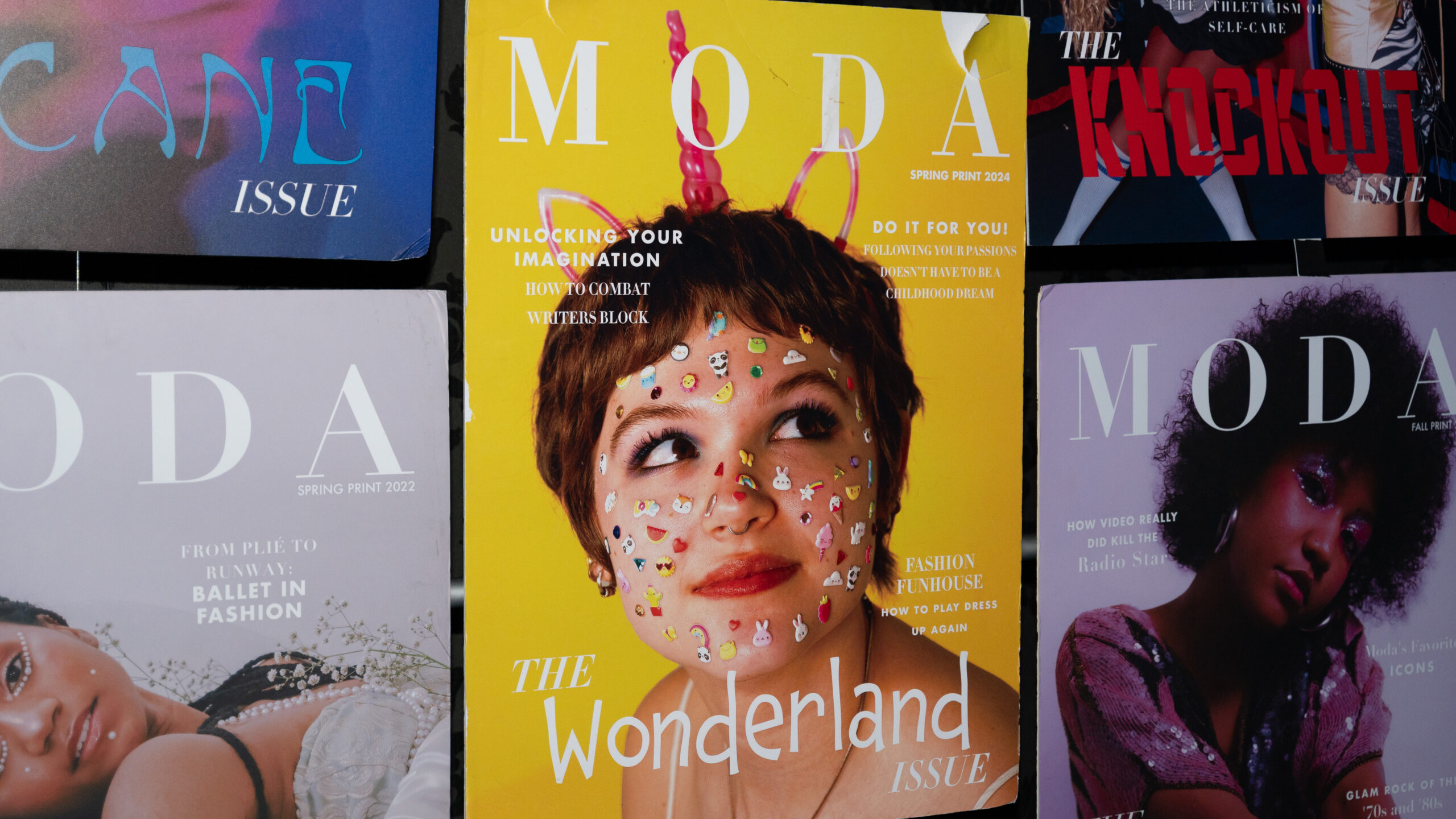 A wall of posters display MODA's latest covers.